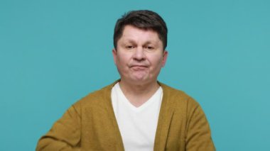Hmm, düşünmem lazım. Beyaz tişörtlü, hırkalı, şaşkın, orta yaşlı bir adamın çenesini ovuşturup karar vermekte tereddüt ettiğinden şüpheliyim. Mavi arka planda kapalı stüdyo çekimi