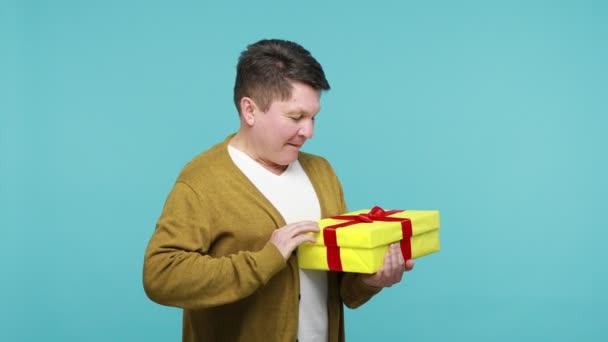 Любопытный Взрослый Мужчина Белой Футболке Кардигане Распаковывает Желтую Подарочную Коробку — стоковое видео
