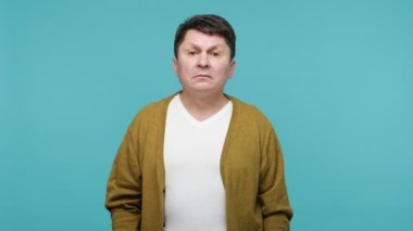Sağırlık ve işitme sorunları. Tişörtlü, hırkalı, orta yaşlı, dikkatli bir adam. Kulağının dibinde durup dikkatlice konuşmaları dinliyor. Gizli haberler. Mavi arka planda kapalı stüdyo çekimleri