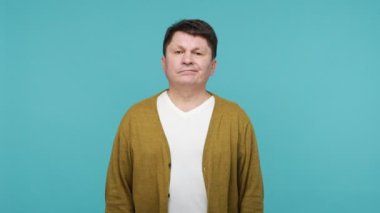 Bu kadar yeter! Beyaz tişörtlü, hırkalı ve kollarında x işareti olan sinirli, olgun bir adam 