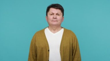 Üzüntülü orta yaşlı tişörtlü ve hırkalı bir adam facepalm hareketi yapıyor. Utanç ve üzüntü duyuyor, önemli şeyleri unutuyor, kötü anıları unutuyor. Mavi arka planda kapalı stüdyo çekimi