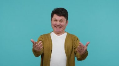 Bedava sarılma! Beyaz tişörtlü, hırkalı, orta yaşlı ve dost canlısı bir adam seni kucaklayacak. Sevindim, heyecanlandım. Mavi arka planda kapalı stüdyo çekimi