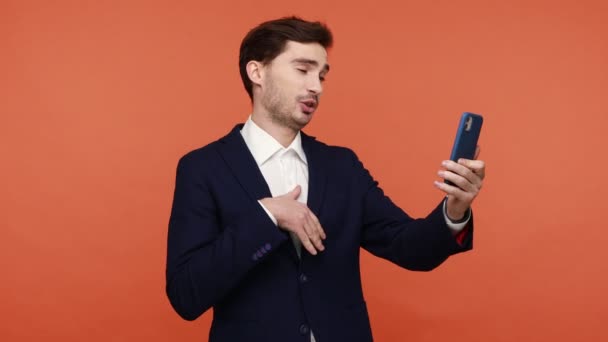 Ein Bärtiger Gutaussehender Mann Schwarzen Anzug Überträgt Smartphone Livestream Winkt — Stockvideo