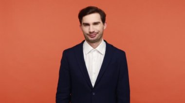 Kötü seçim. Takım elbiseli mutsuz genç adam, hoşlanmadığını gösteriyor, olumsuz jest yapıyor, olumsuz not veriyor, reddedildiğini ifade ediyor, tiksinti ifadesi var. Turuncu arka planda kapalı stüdyo çekimleri