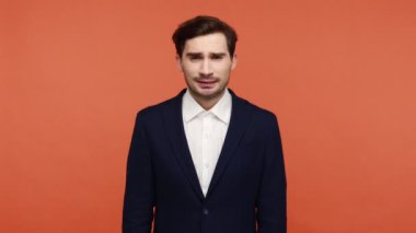 Önemli olaylardan önce endişelenen mutsuz, genç esmer adam şans diliyor, zafer umuduyla, hayallerinin gerçekleşmesini diliyor. Turuncu arka planda kapalı stüdyo çekimleri