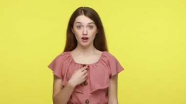 Bu ben miyim? Kahverengi saçlı, kendini gösteren, kişisel başarılarına şaşırmış görünen, kendi başarısına inanamayan bir kadın. Sarı arka planda izole edilmiş kapalı alan stüdyosu..