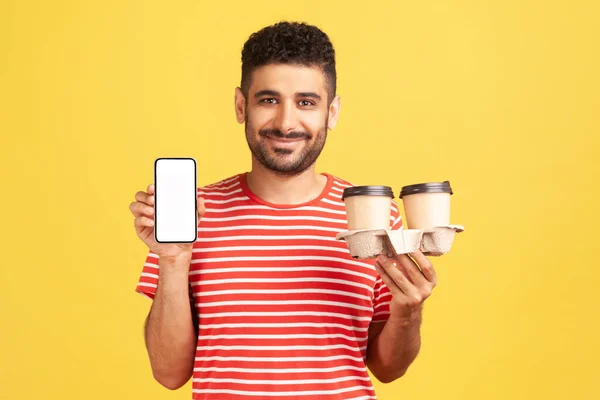 Çizgili Tişörtlü Sakallı Elinde Boş Akıllı Telefonu Olan Elinde Kahve — Stok fotoğraf