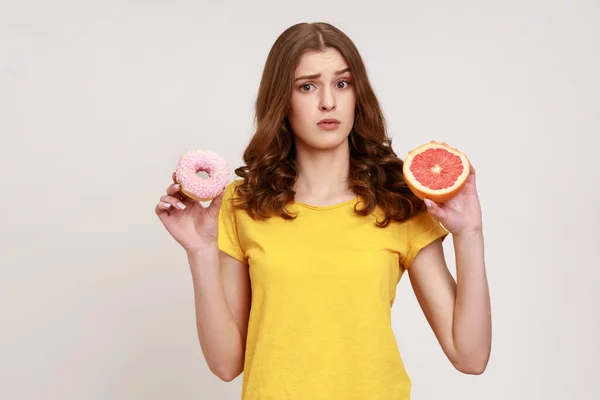 Sad Teenager Girl Holding Healthy Fruits High Calorie Dessert Confused — Stock Photo, Image