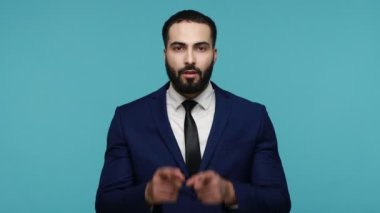 Hey sen! Aşırı neşeli, esmer, takım elbiseli sakallı adam şok olmuş gözlerle kameraya bakıyor, seni seçiyor ve vay canına diyor. Mavi arka planda kapalı stüdyo çekimi.