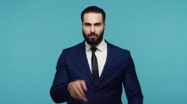 Yorgun, esmer, resmi takım elbiseli çekici bir adam el hareketi yapıyor ve teslim tarihini kaldırmak için yalvarıyor. Ara verilmesi gerekiyor. Mavi arka planda kapalı stüdyo çekimi.