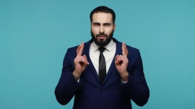 Takım elbiseli, sakallı, çaresiz, yakışıklı esmer adam şans dilemek için şans diliyor ve yalvararak 