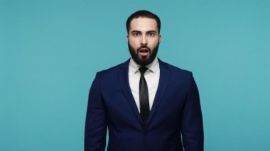 Hiçbir şey söylemeyeceğim! Yakışıklı, koyu renk saçlı adam ağzını görünmez fermuarla kapatıyor, sır saklayıp sessiz kalacağına yemin ediyor. Mavi arka planda kapalı stüdyo çekimi.