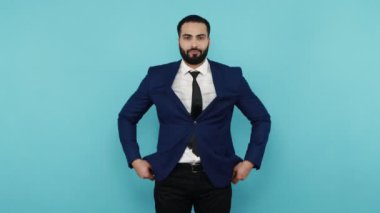 Nakit yok, maddi desteğe ihtiyacım var. Zavallı sakallı iş adamı cepleri bomboş, parası yok, borç sorunu ve iflası yok. Mavi arka planda kapalı stüdyo çekimi.