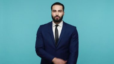 Kendimi seviyorum! Resmi tarzda giyinmiş, kendini kucaklayan, okşayan, kendini seven, kendine güvenen, destekleyen mutlu, egoist genç sakallı bir adam. Mavi arka planda kapalı stüdyo çekimi.
