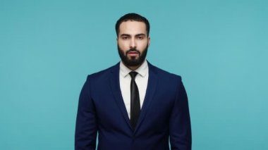 Alnında L işareti olan şanssız sakallı bir iş adamı, ezik jestleri gösteriyor, işten çıkarılmaya üzülüyor, hayat zorlukları yaşıyor. Mavi arka planda kapalı stüdyo çekimi.