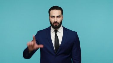 Takım elbiseli çekici iş adamı başarısızlığınla alay ediyor, kamerayı işaret ediyor ve L işareti gösteriyor, başarısızlıkla suçlanıyor, saygısızlığını dile getiriyor. Mavi arka planda kapalı stüdyo çekimi.