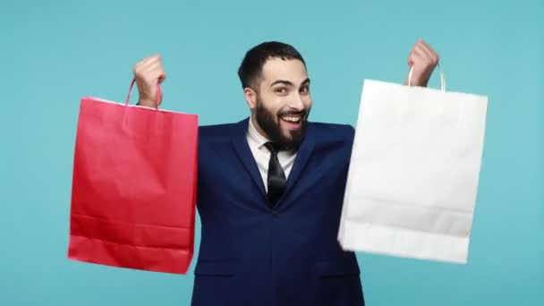 Podekscytowany Szczęśliwy Klient Garniturze Biznesowym Podnosząc Torby Zakupy Wyglądając Zadowolony — Wideo stockowe