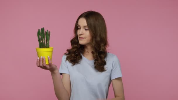 Vakre Tenåringsjente Holder Blomsterpott Med Kaktus Hendene Har Morsomt Uttrykk – stockvideo