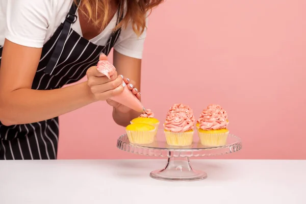 Imagem Recortada Mulher Padaria Decoração Muffins Com Creme Rosado Usando — Fotografia de Stock