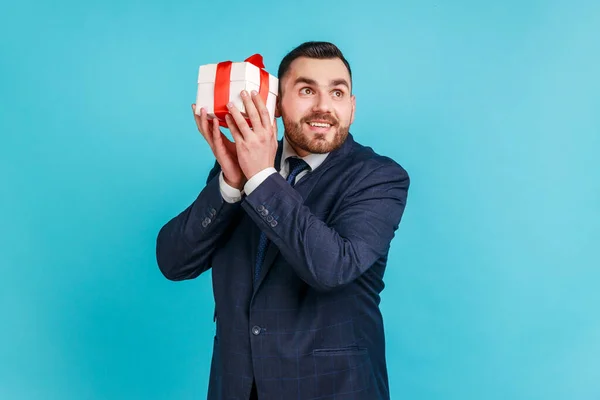 Nieuwsgierige Dromerige Bebaarde Man Elegant Pak Schudden Geschenkdoos Proberen Raden — Stockfoto