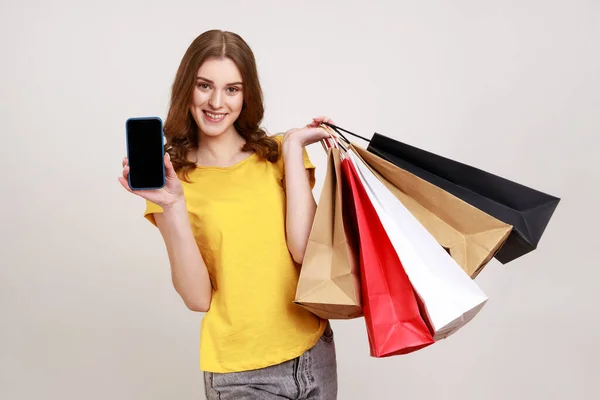 Sarı Tişörtlü Mutlu Genç Kızın Portresi Cep Telefonu Alışveriş Poşetleri — Stok fotoğraf