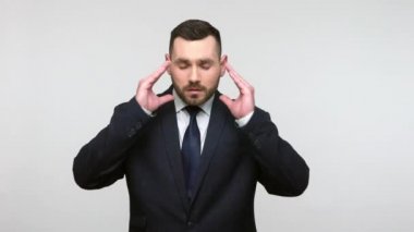 Sağlıksız, depresif sakallı bir iş adamının portresi. Resmi giyinmiş, migren ağrısı çeken, yüksek tansiyonu olan korkunç bir iş adamı. Gri arka planda izole edilmiş kapalı stüdyo görüntüleri.