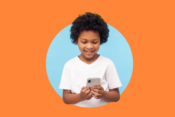 스마트폰으로 머리를 곱슬곱슬 웃으며 아이들의 모바일 만족하고 핸드폰을 사용하는 오렌지 — 스톡 사진