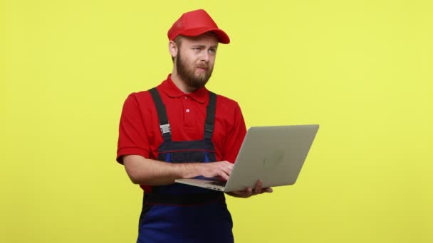 Бородатый Техник Работающий Ноутбуке Думающий Новом Проекте Одетый Синюю Униформу — стоковое видео