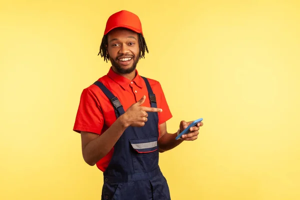 Optimistisk Hantverkare Eller Mekaniker Bär Uniform Pekar Smart Telefon Med — Stockfoto