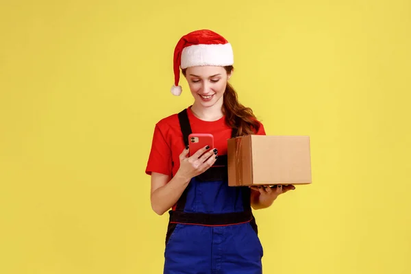 Courier Fêmea Com Pacote Papelão Usando Telefone Inteligente Olhando Para — Fotografia de Stock