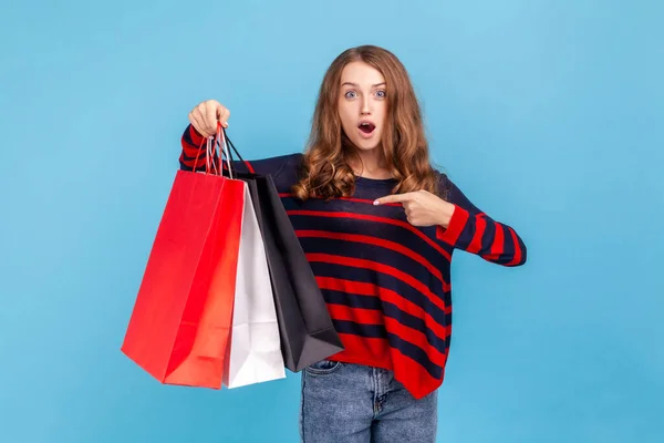 Überraschte Frau Gestreiftem Lässigem Pullover Zeigt Auf Einkaufstüten Blickt Mit — Stockfoto