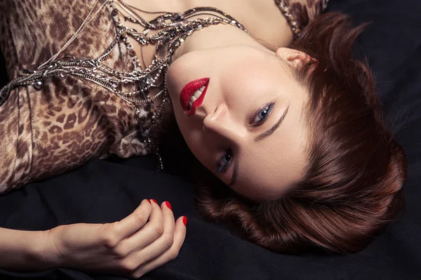 High fashion look. Glamor closeup portrait of beautiful sexy stylish woman model lying on black bed with bright makeup, with red lips, with perfect clean on bed — Stock Photo, Image