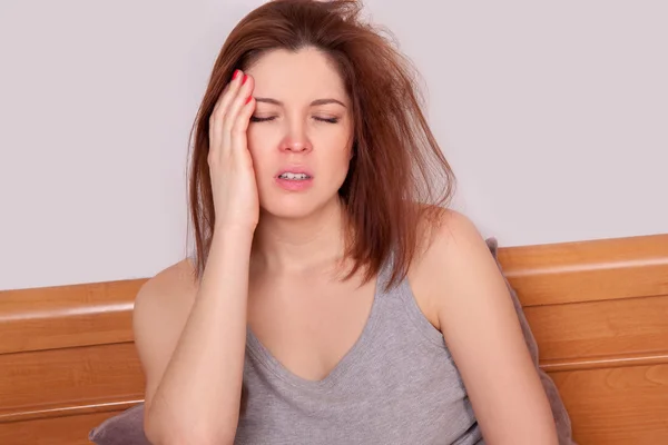 Flu atau dingin. Gambar close-up top wanita muda yang frustrasi dengan hidung merah dan menderita sakit kepala yang mengerikan di tempat tidur — Stok Foto