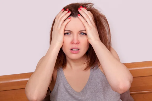 Flu or cold. Closeup top view image of frustrated young woman with red nose and suffering from terrible headache in bed — Stock Photo, Image