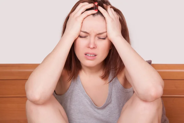 Flu or cold. Closeup top view image of frustrated young woman with red nose and suffering from terrible headache in bed — Stock Photo, Image