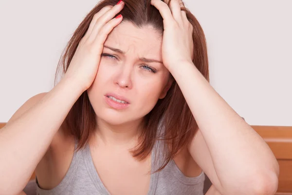 Flu atau dingin. Gambar close-up top wanita muda yang frustrasi dengan hidung merah dan menderita sakit kepala yang mengerikan di tempat tidur — Stok Foto