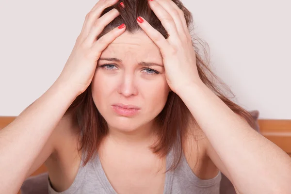 Flu or cold. Closeup top view image of frustrated young woman with red nose and suffering from terrible headache in bed — Stock Photo, Image