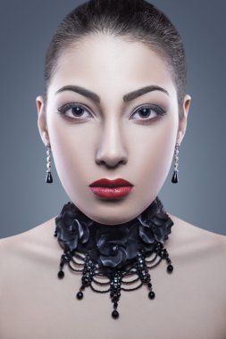Portrait of black angel with dark nad red makeup, studio shot. looking at camera. dark blue background. Developed from RAW, edited with special care and attention.