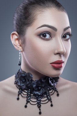 Portrait of black angel with dark nad red makeup, studio shot. looking at camera. dark blue background. Developed from RAW, edited with special care and attention.