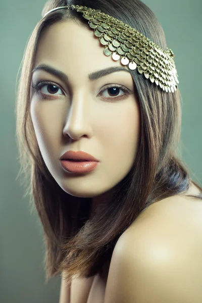 Beautiful fashion model with makeup and jewelry is looking at camera. green background, studio shot. Developed from RAW, edited with special care and attention — Stockfoto