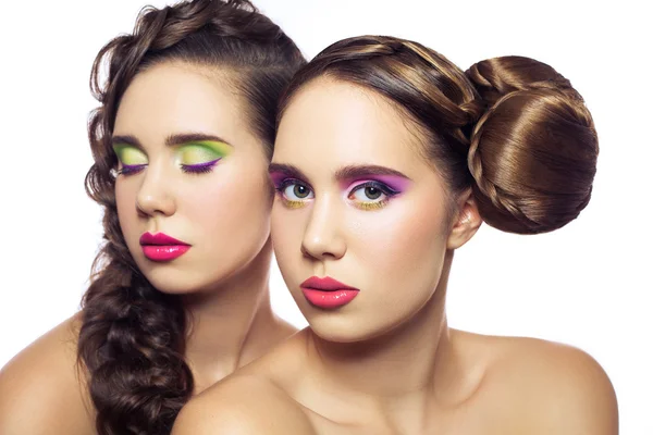 Retrato de belos gêmeos jovens mulheres da moda com penteado e maquiagem verde rosa vermelha. isolado em fundo branco. a olhar para a câmara de olhos fechados. retocada com especial cuidado e atenção . — Fotografia de Stock