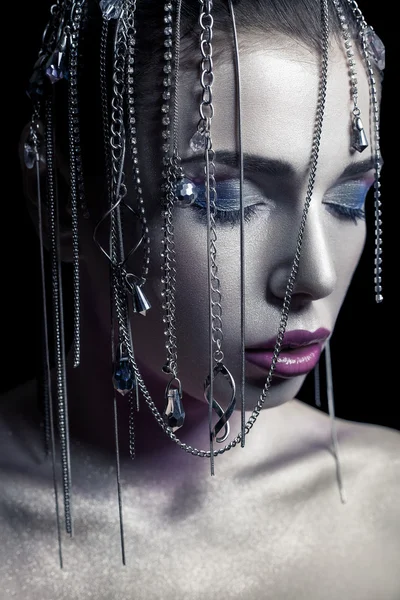 Different style of beauty. young beautiful fashion model with silver, purple, blue makeup and shiny silver jewelry chain on her face. studio low key shot. retouched with special care and attention. — 스톡 사진