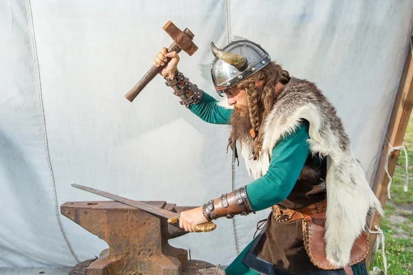 Strong viking is repairing his sword — Stock Photo, Image