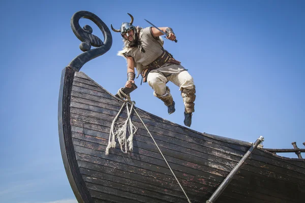 Strong Viking jumping from his ship to attack Stockbild