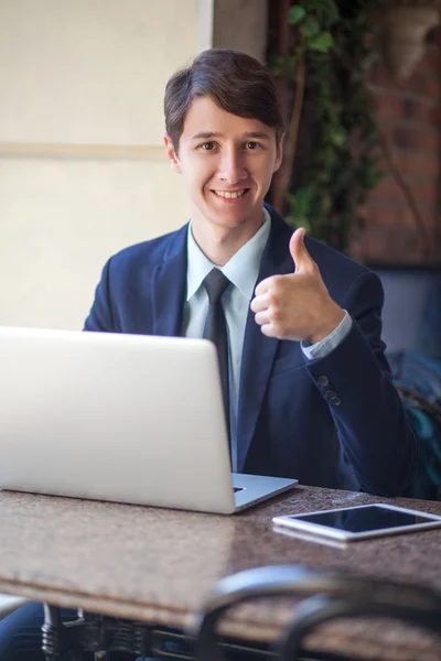 One relaxed young handsome professional businessman working with his laptop, phone and tablet in a noisy cafe. — Stock Photo, Image