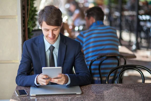 1 リラックスした若いハンサムなプロ実業家彼のラップトップの使用携帯電話やカフェでタブレット. — ストック写真
