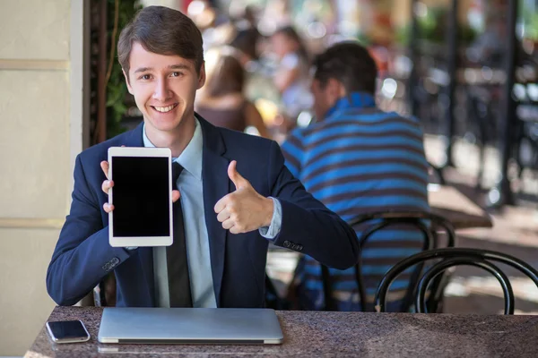 One relaxed young handsome professional businessman working with his laptop, phone and tablet in a noisy cafe. — Stock Photo, Image