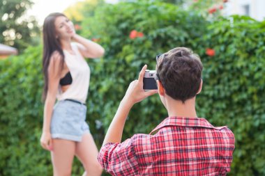 The man shooting one beautiful fashion model near green wall