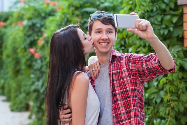 Happy young couple doing selfie by smart mobile phone in the city. — Stockfoto