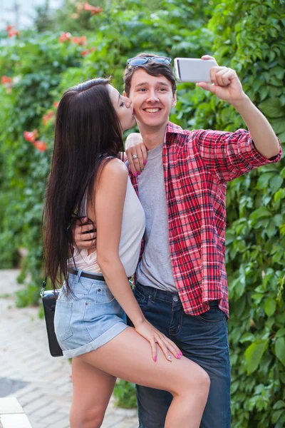 Feliz joven pareja haciendo selfie por teléfono móvil inteligente en la ciudad . — Foto de Stock